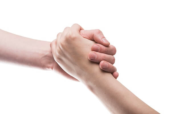 Two people holding hands, symbolizing unavoidable situations a freelance web designer can help you with.
